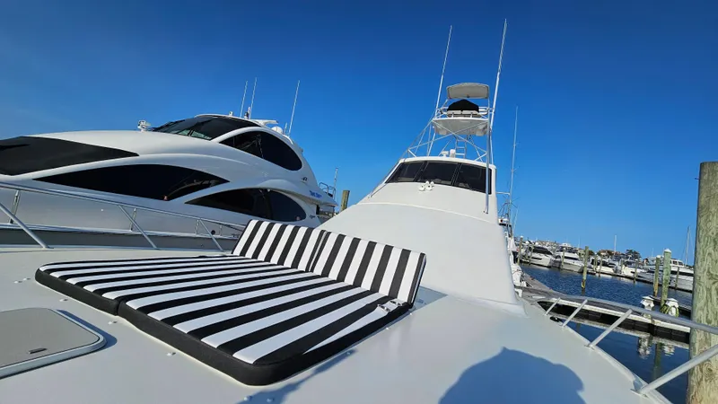 Slide: The Image of Ocean Yachts 70 Super Sport 2000 with striped sunbed, docked at marina under clear blue sky. - 22