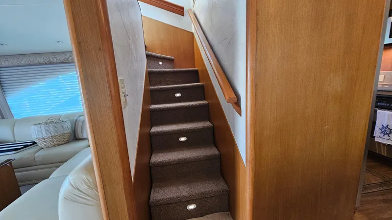Slide: The Image of Staircase inside 2000 Ocean Yachts 70 Super Sport, featuring carpeted steps and wooden handrails. - 33