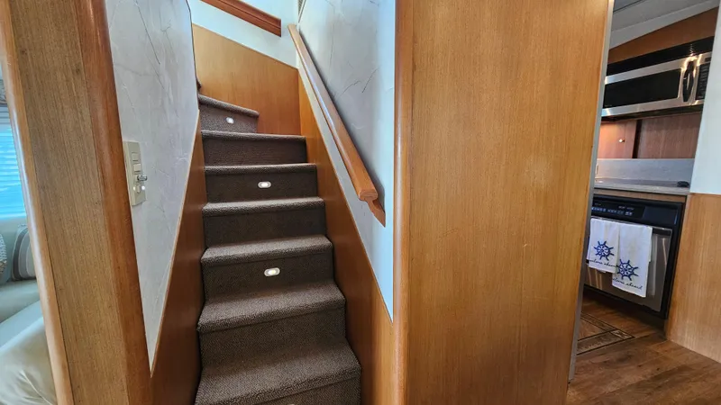 Slide: The Image of Staircase and kitchen area inside 2000 Ocean Yachts 70 Super Sport. - 34
