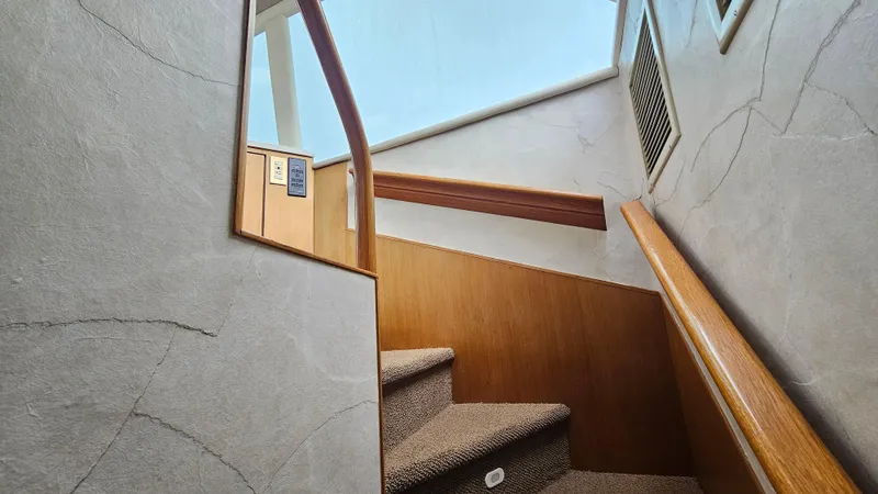 Slide: The Image of Staircase inside 2000 Ocean Yachts 70 Super Sport, featuring wooden handrails and carpeted steps. - 36