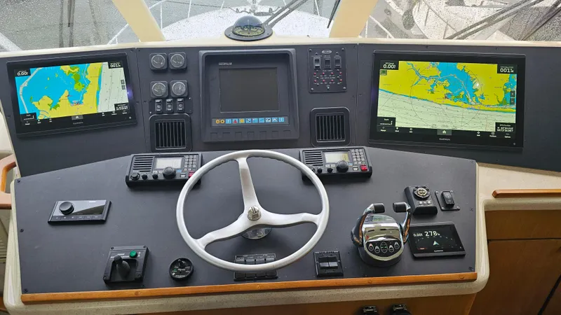 Slide: The Image of Control panel of a 2000 Ocean Yachts 70 Super Sport with navigation screens and steering wheel. - 47