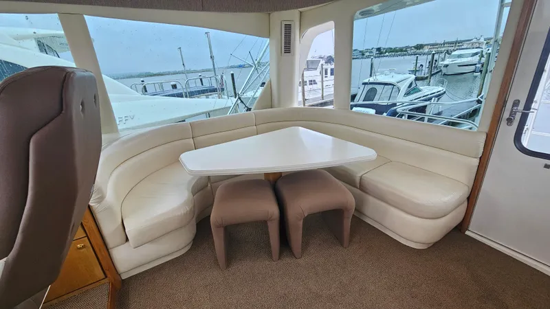 Slide: The Image of Interior of 2000 Ocean Yachts 70 Super Sport with white seating and triangular table. - 50