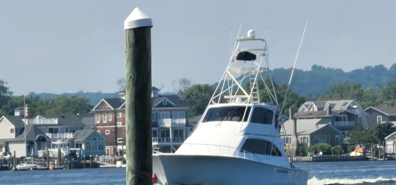 Slide: The Image of Ocean Yachts 70 Super Sport 2000 cruising near waterfront homes and dock. - 6