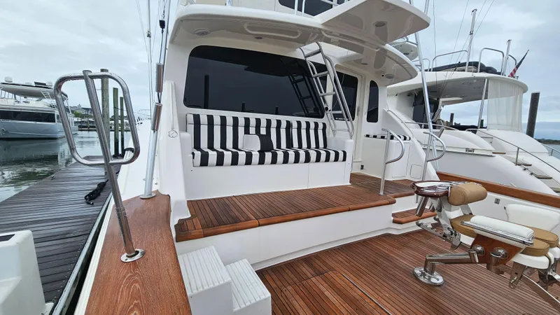Slide: The Image of Ocean Yachts 70 Super Sport 2000 model with striped seating and wooden deck at marina. - 9
