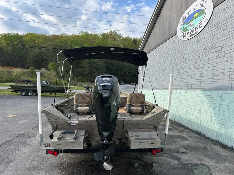Slide: The Image of 2018 SeaArk 2072 RIVERCAT 200 CC boat with outboard motor, parked outside a marine shop. - 5