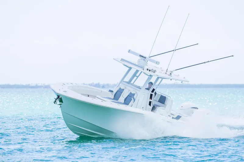 Slide: The Image of 2024 Invincible 33 Open Fisherman boat cruising on clear blue water. - 14