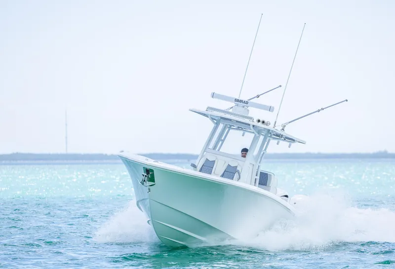 Slide: The Image of 2024 Invincible 33 Open Fisherman boat cruising on clear blue water. - 15