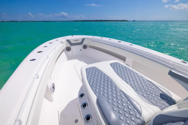 Slide: The Image of 2024 Invincible 33 Open Fisherman boat on turquoise water, featuring sleek seating and modern design. - 27