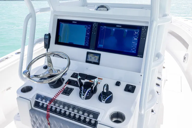 Slide: The Image of 2024 Invincible 33 Open Fisherman boat dashboard with dual navigation screens. - 34