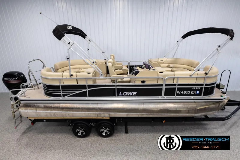 Slide: The Image of 2016 Lowe SS230 pontoon boat with Mercury engine, beige seating, and black accents on a trailer. - 1