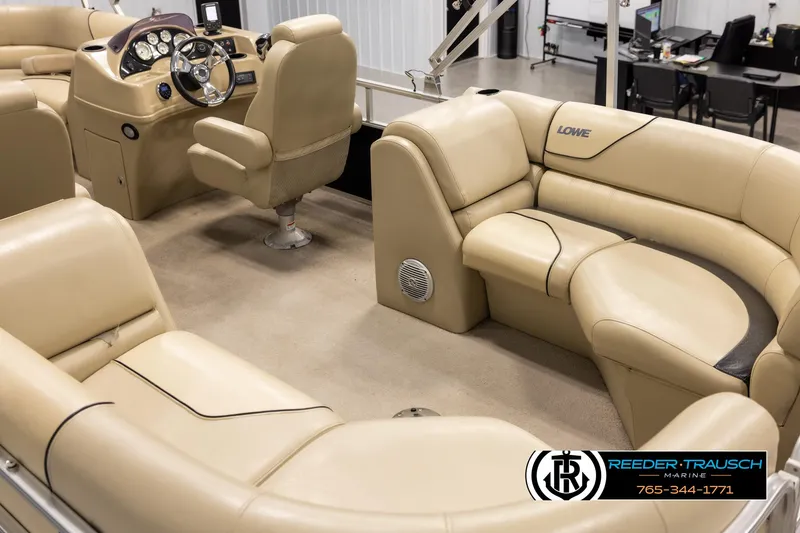 Slide: The Image of 2016 Lowe SS230 pontoon boat interior with beige seating and steering console. - 11