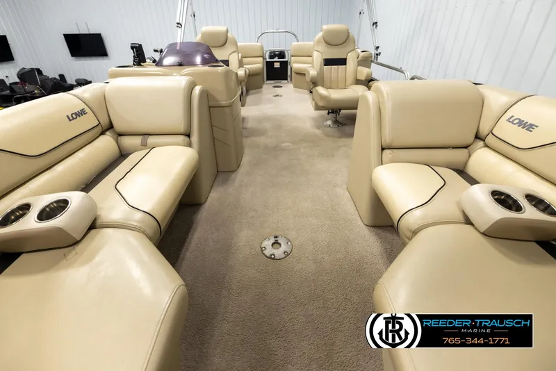 Slide: The Image of 2016 Lowe SS230 pontoon boat interior with beige seating and cup holders. - 13