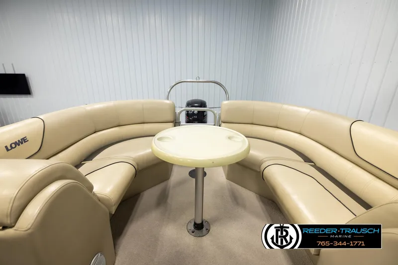 Slide: The Image of 2016 Lowe SS230 boat interior with beige seating and round table. - 17