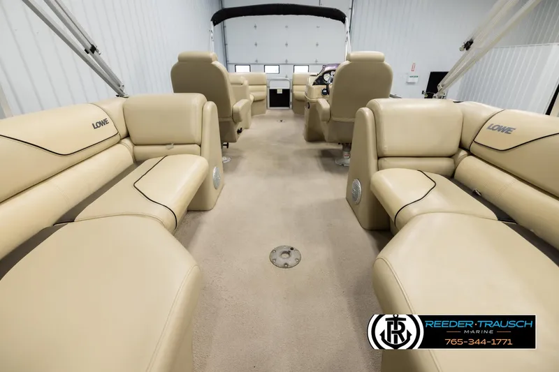 Slide: The Image of Interior of a 2016 Lowe SS230 pontoon boat with beige seating and carpet. - 18