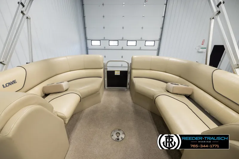 Slide: The Image of 2016 Lowe SS230 pontoon boat interior with beige seating in a garage. - 20