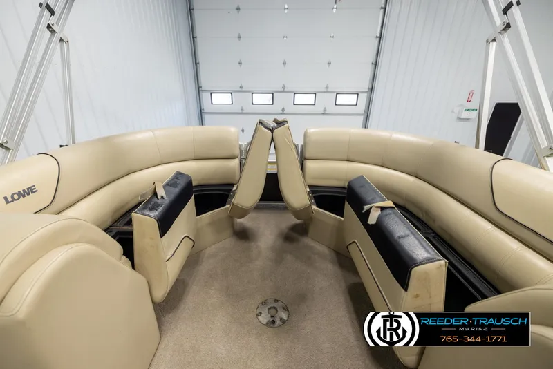 Slide: The Image of 2016 Lowe SS230 boat interior with beige seating in a garage setting. - 21
