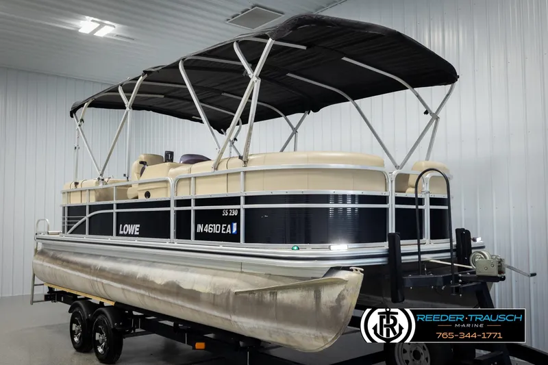 Slide: The Image of 2016 Lowe SS230 pontoon boat with canopy on trailer in indoor storage. - 3