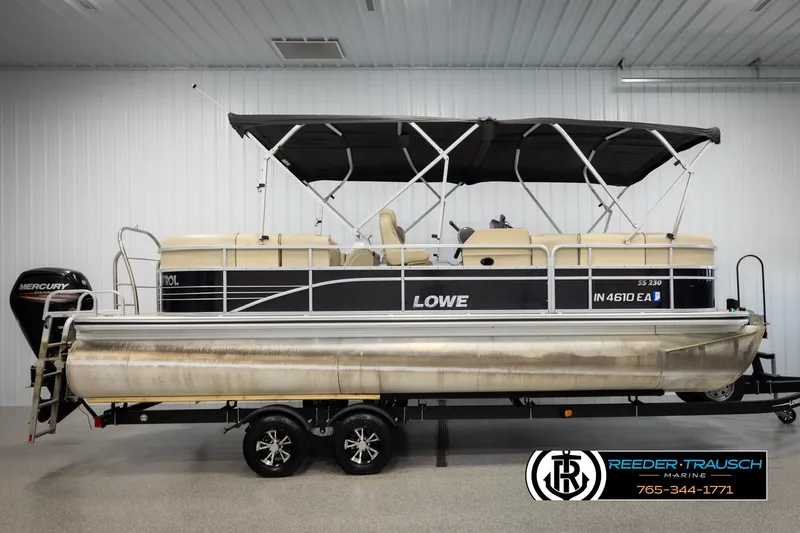 Slide: The Image of 2016 Lowe SS230 pontoon boat with canopy on trailer in indoor showroom. - 5
