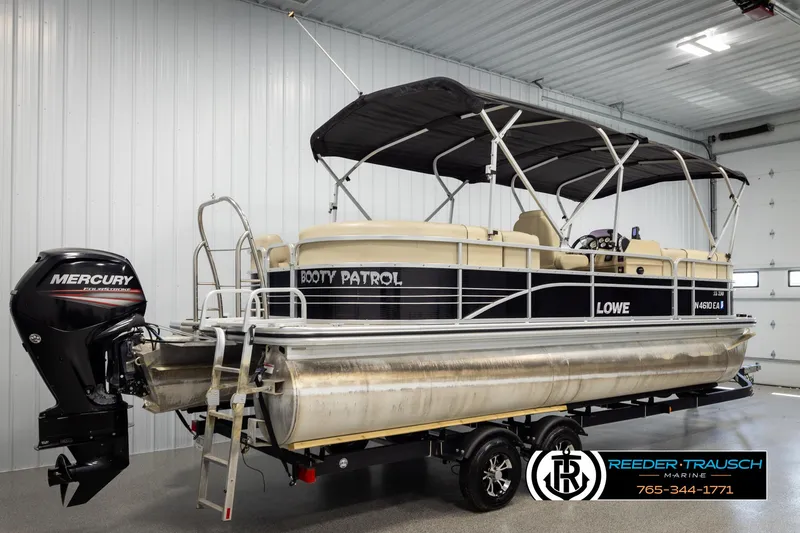 Slide: The Image of 2016 Lowe SS230 pontoon boat with Mercury outboard motor in a garage setting. - 6
