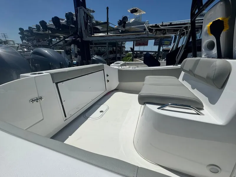 Slide: The Image of 2022 Cape Horn 27 XS boat with sturdy T-top and rod holders, set against a leafy backdrop. - 15