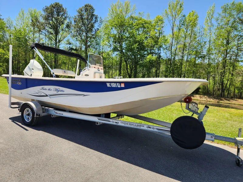 Slide: The Image of 2018 Carolina Skiff 218 DLV boat on trailer, parked on a sunny day. - 1