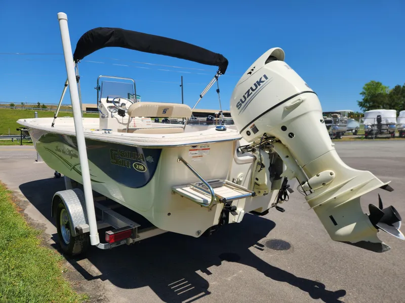 Slide: The Image of 2018 Carolina Skiff 218 DLV boat with Suzuki outboard motor on trailer. - 4