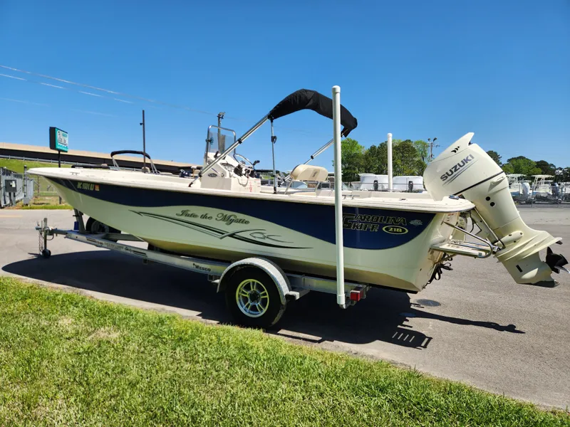 Slide: The Image of 2018 Carolina Skiff 218 DLV boat with Suzuki outboard motor on a trailer. - 5