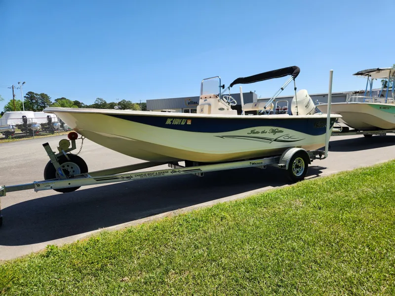 Slide: The Image of 2018 Carolina Skiff 218 DLV boat on trailer, parked outdoors on a sunny day. - 7