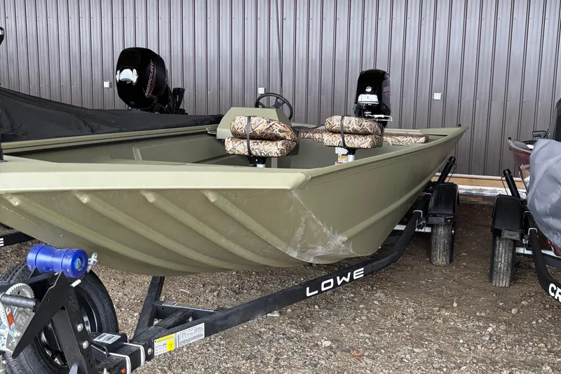 Slide: The Image of 2025 Lowe Roughneck 1860 boat on trailer, parked outdoors. - 3
