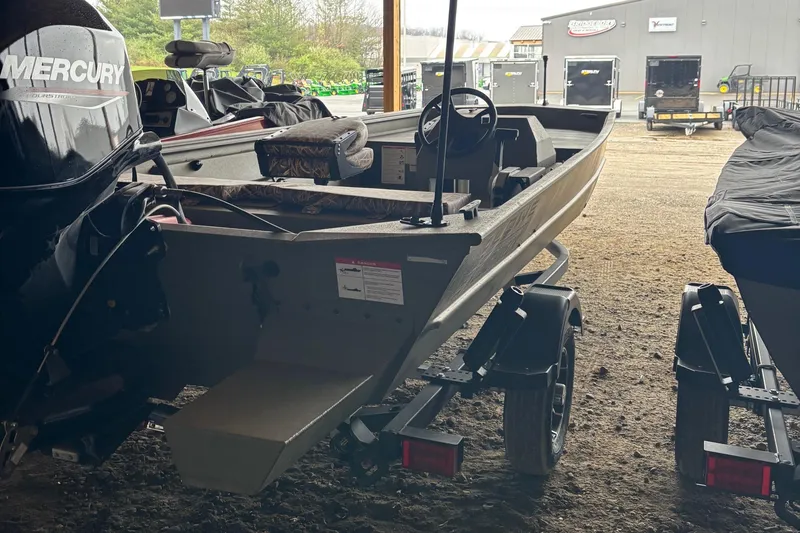 Slide: The Image of 2025 Lowe Roughneck 1860 boat on trailer in a storage area. - 5