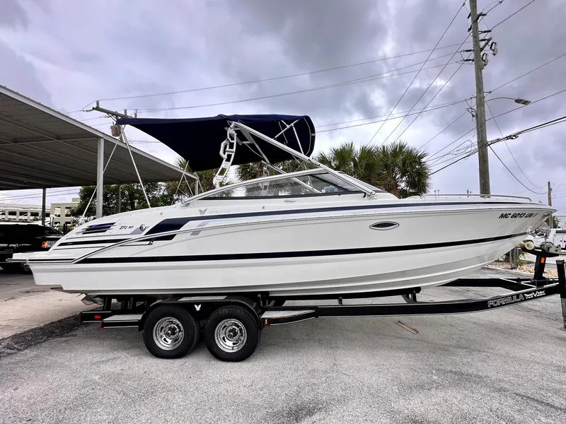 Slide: The Image of 2021 Formula 270 Bowrider boat on trailer, parked outdoors under cloudy sky. - 3