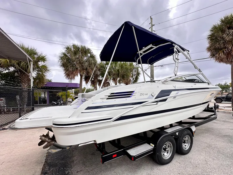 Slide: The Image of 2021 Formula 270 Bowrider boat on trailer with canopy, parked outdoors. - 4