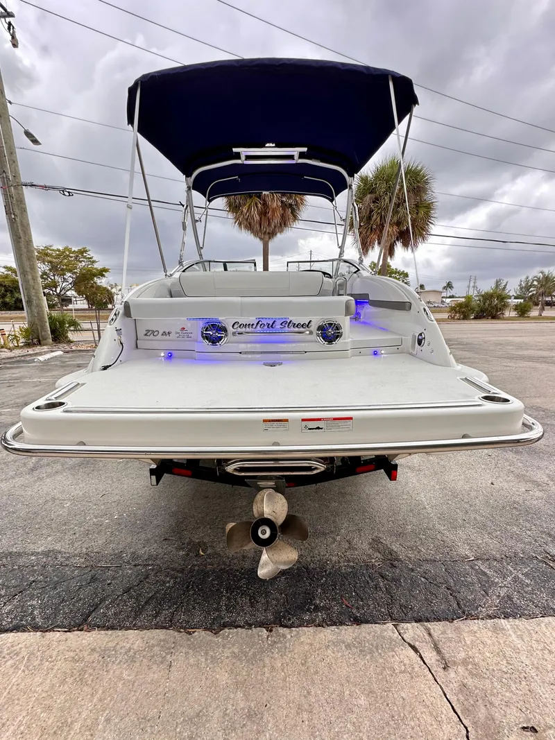 Slide: The Image of 2021 Formula 270 Bowrider boat with canopy, parked on pavement, rear view. - 6