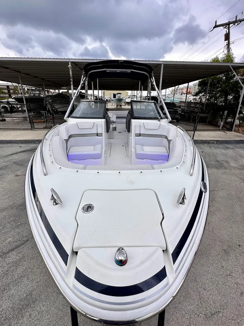 Slide: The Image of 2021 Formula 270 Bowrider boat with sleek design, docked under cloudy skies. - 8