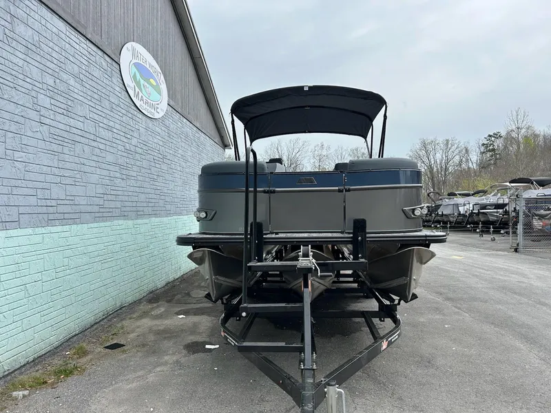 Slide: The Image of 2025 Avalon 2585 Catalina Quad Lounger pontoon boat on trailer, parked outside a marine facility. - 3