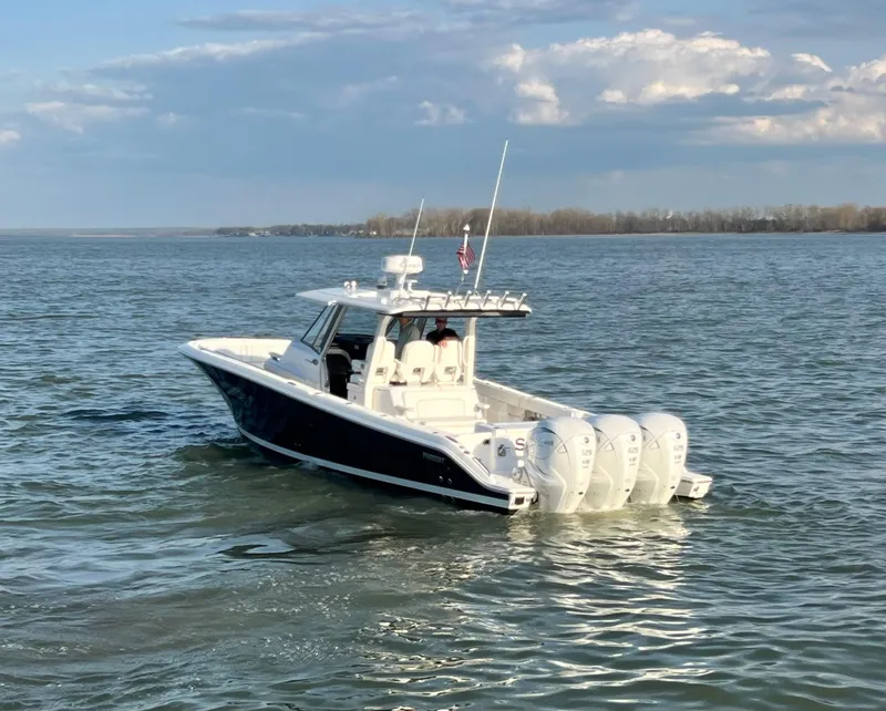 Slide: The Image of 2022 Pursuit S 378 Sport boat cruising on open water under a partly cloudy sky. - 12