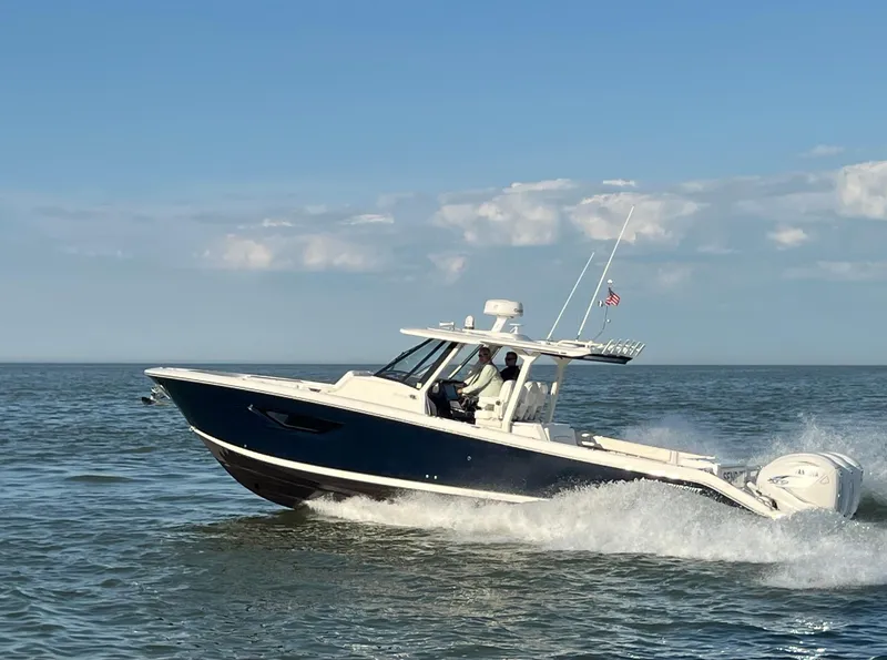 Slide: The Image of 2022 Pursuit S 378 Sport boat cruising on open water under clear skies. - 2