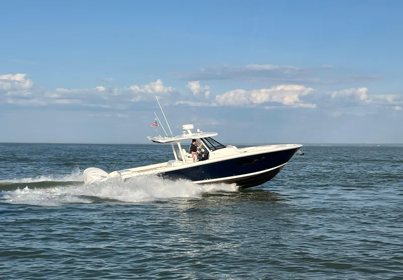 Slide: The Image of 2022 Pursuit S 378 Sport boat cruising on open water under a clear blue sky. - 3