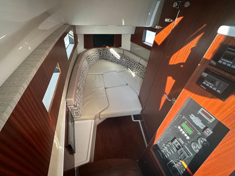 Slide: The Image of 2022 Pursuit S 378 Sport cabin interior with cushioned seating and control panel. - 31