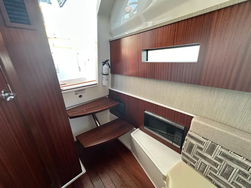 Slide: The Image of Interior of 2022 Pursuit S 378 Sport boat with wooden accents and seating. - 33