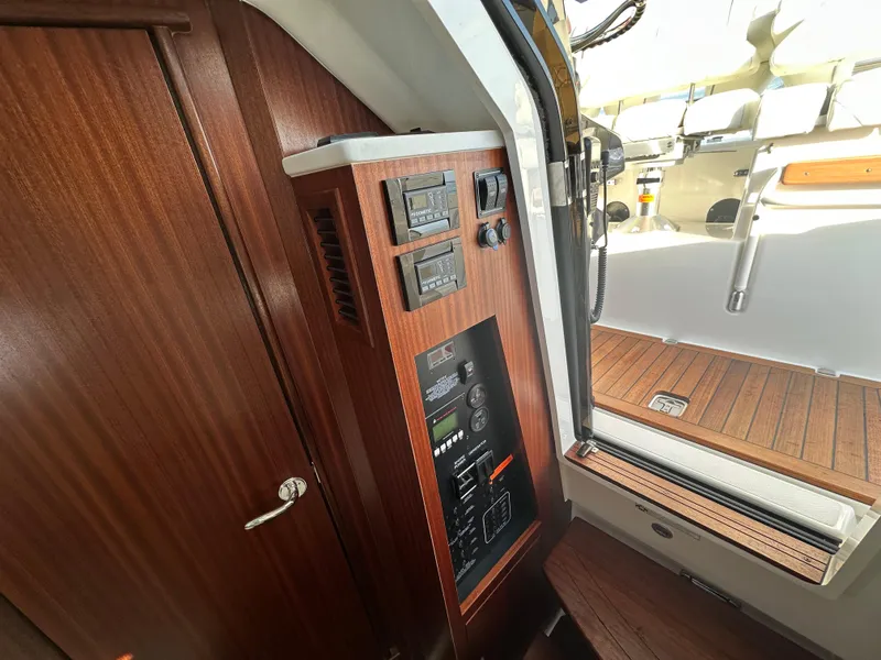 Slide: The Image of Interior view of 2022 Pursuit S 378 Sport boat with wooden paneling and control panel. - 36