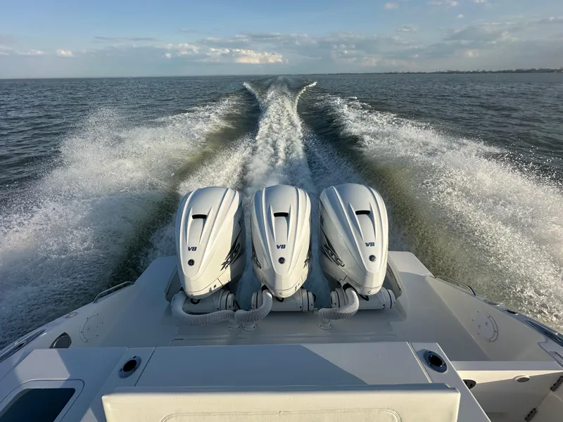 Slide: The Image of 2022 Pursuit S 378 Sport boat with triple V8 engines cruising on open water. - 8