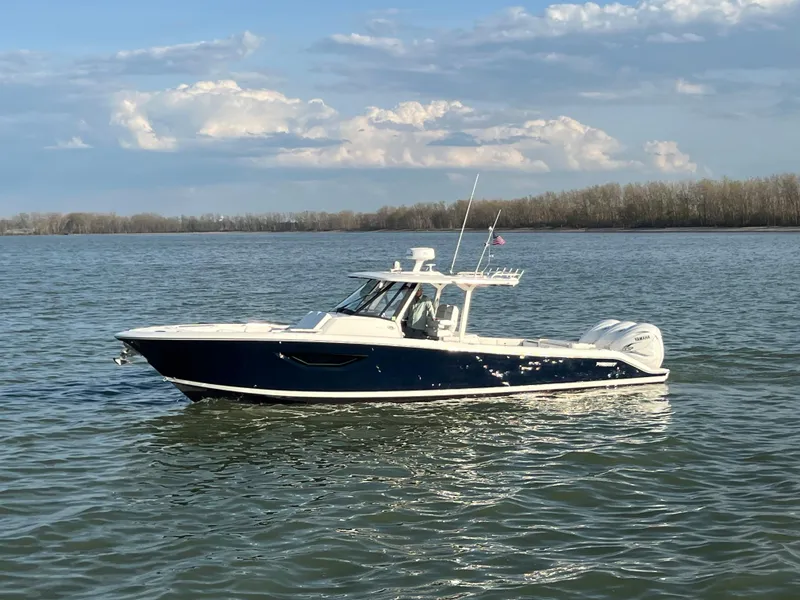 Slide: The Image of 2022 Pursuit S 378 Sport boat on calm water under a partly cloudy sky. - 9