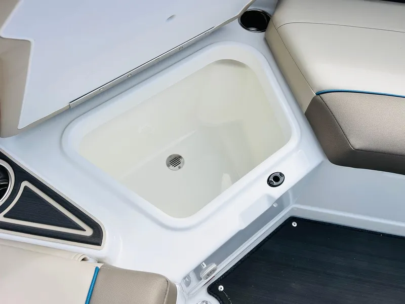 Slide: The Image of 2024 Tahoe 210 S Limited boat storage compartment with cushioned seating and drain. - 32