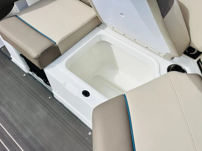 Slide: The Image of 2024 Tahoe 210 S Limited boat storage compartment with beige seating and gray flooring. - 35