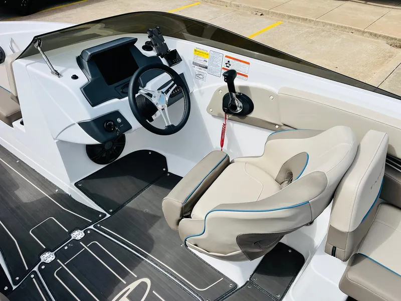 Slide: The Image of 2024 Tahoe 210 S Limited boat interior with steering wheel and seating. - 38