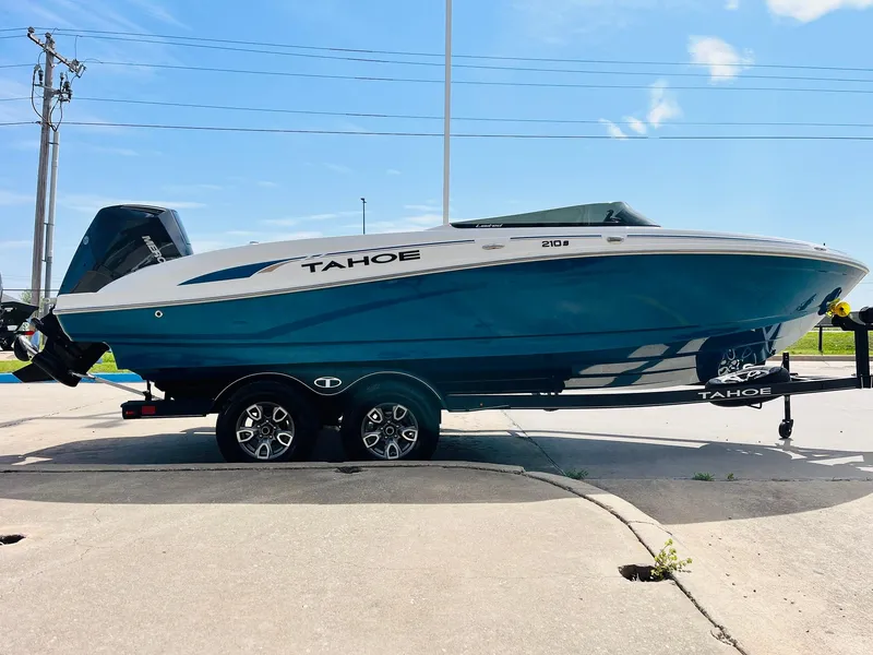 Slide: The Image of 2024 Tahoe 210 S Limited boat on trailer, parked outdoors under clear sky. - 4