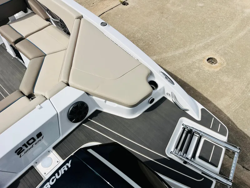 Slide: The Image of 2024 Tahoe 210 S Limited boat interior with beige seating and Mercury engine. - 45