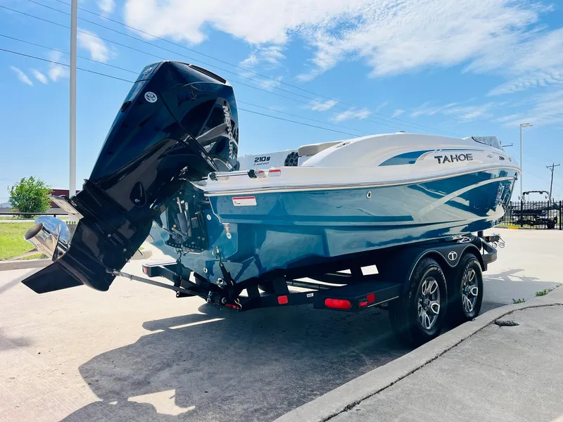 Slide: The Image of 2024 Tahoe 210 S Limited boat on trailer, blue and white design, sunny day. - 5