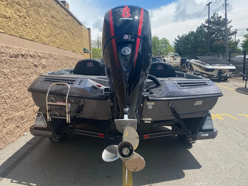 Slide: The Image of 2025 Ranger Z518 Cup-Equipped boat, rear view with motor, parked outdoors. - 3